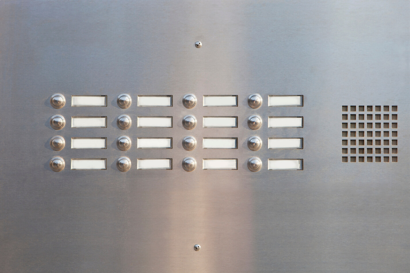 Panel de intercomunicación de acero inoxidable con botones y etiquetas en blanco.