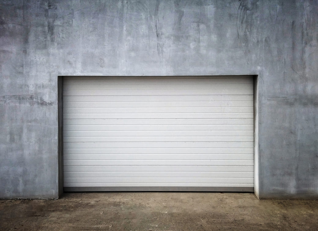 Puerta de garaje cerrada en una pared de concreto.